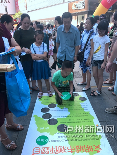 市民在宣傳點(diǎn)參加創(chuàng)文趣味游戲。 記者 朱虹 攝